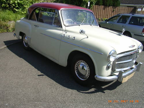 A classic car image - a white saloon with a red "soft top".